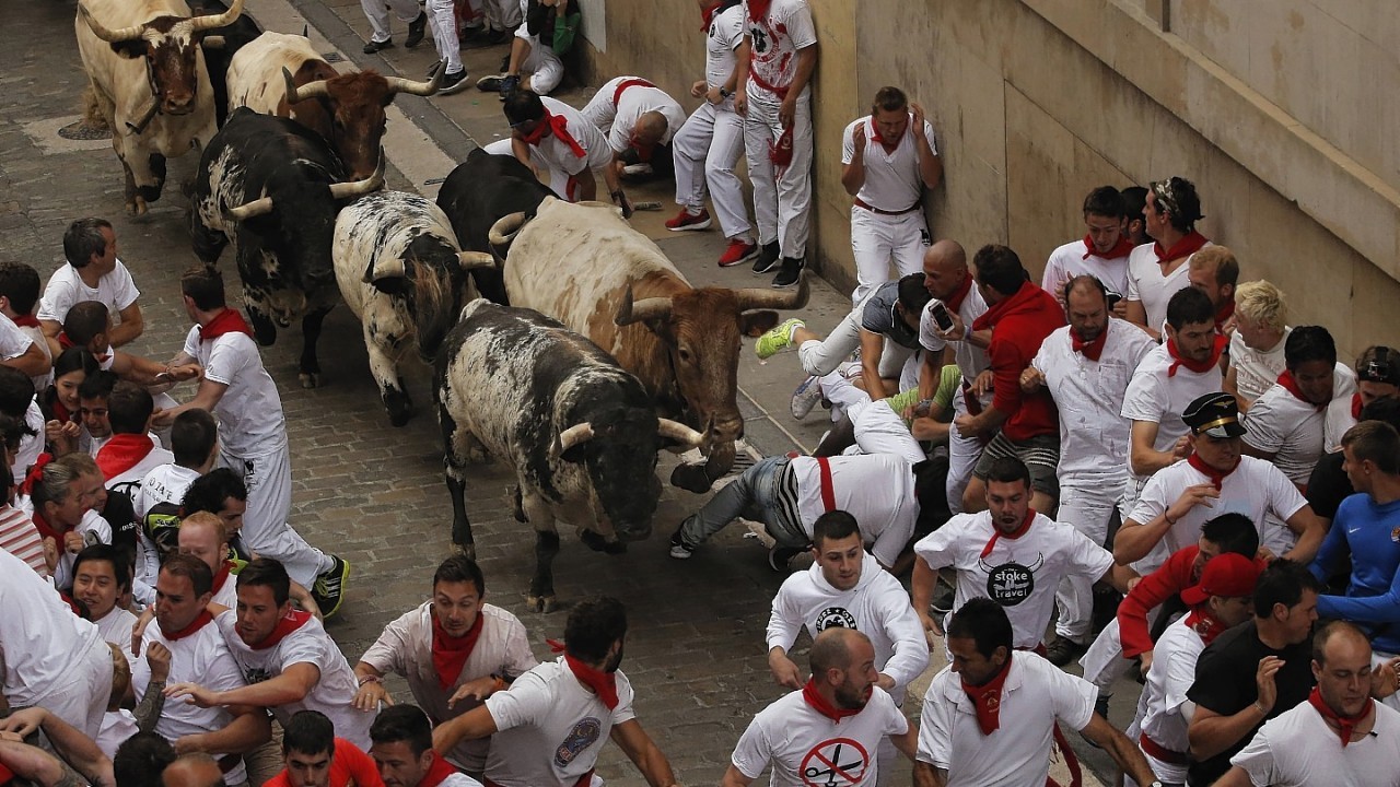 Torrestrella fighting bulls and revelers run during the running of the bulls of the San Fermin festival, in Pamplona, Spain, Monday, July 7, 2014