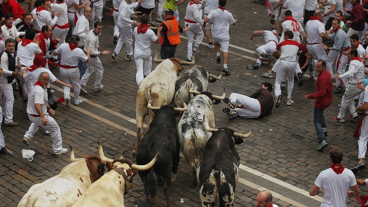 Torrestrella fighting bulls and revelers run during the running of the bulls of the San Fermin festival, in Pamplona, Spain, Monday, July 7, 2014