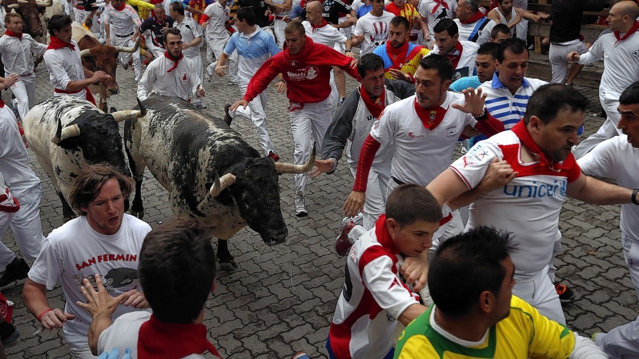 Torrestrella fighting bulls and revelers run during the running of the bulls of the San Fermin festival, in Pamplona, Spain, Monday, July 7, 2014