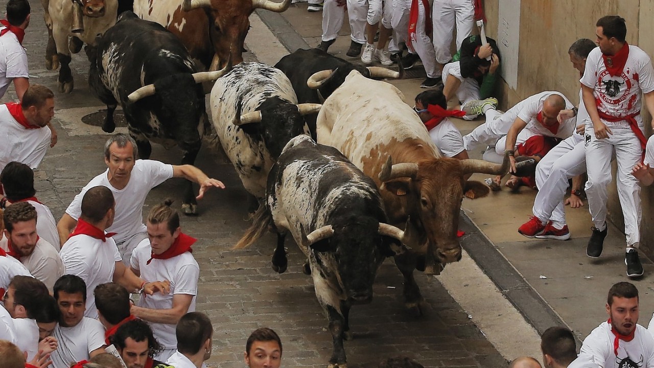 Torrestrella fighting bulls and revelers run during the running of the bulls of the San Fermin festival, in Pamplona, Spain, Monday, July 7, 2014