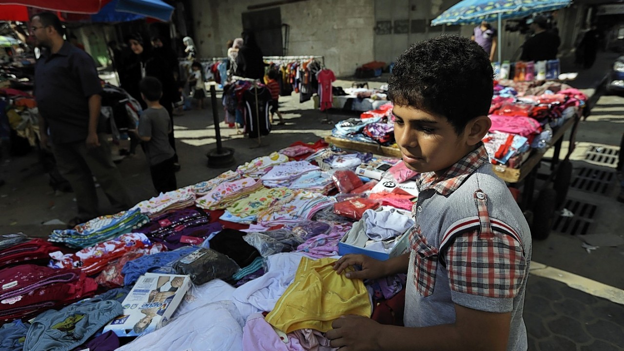 A Palestinian vendor arranges his merchandise at a market in Gaza City, northern Gaza Strip, Wednesday, Aug. 6, 2014.