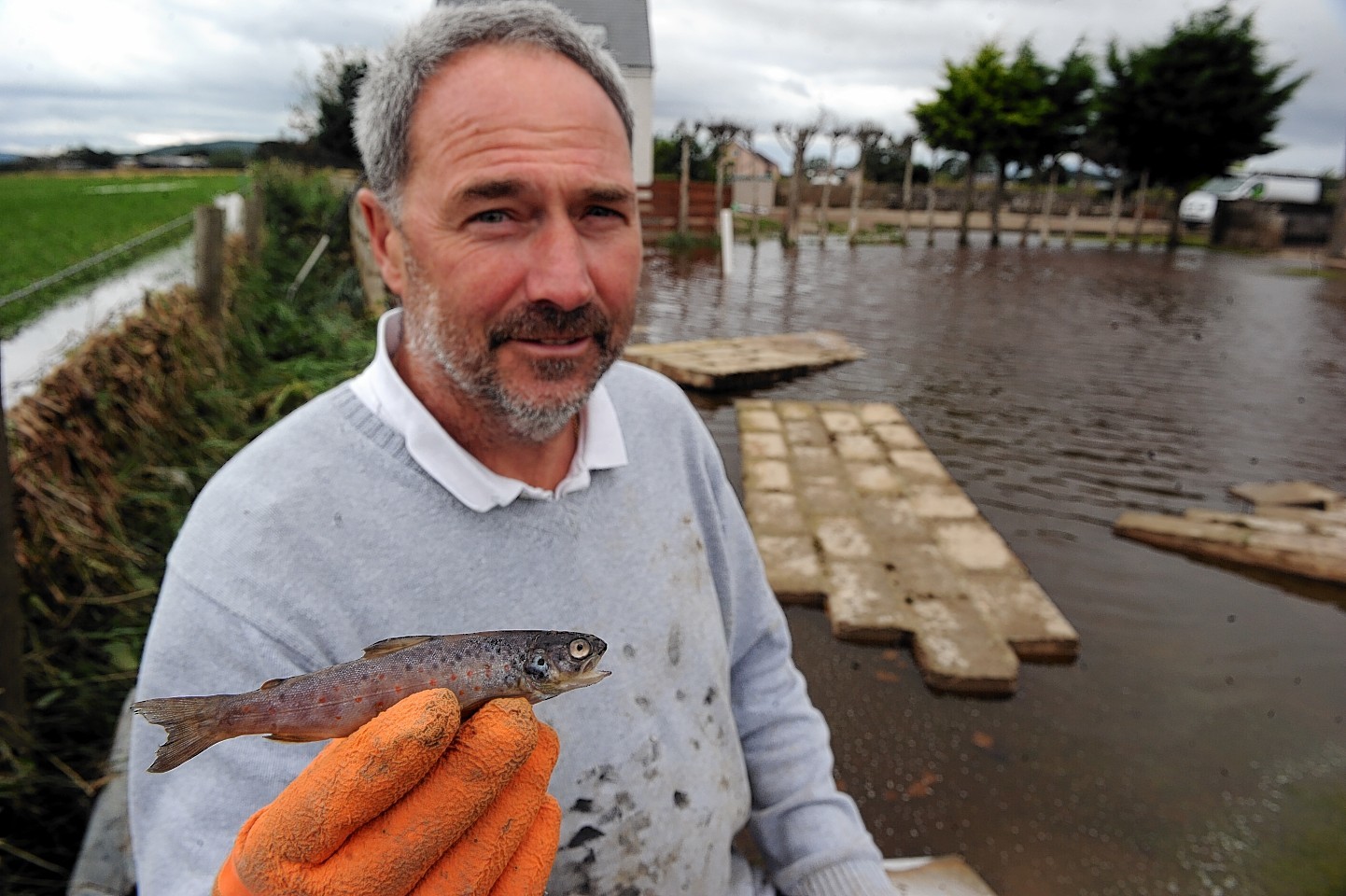 Graeme Lees shows the salmon parr he found in the flood water