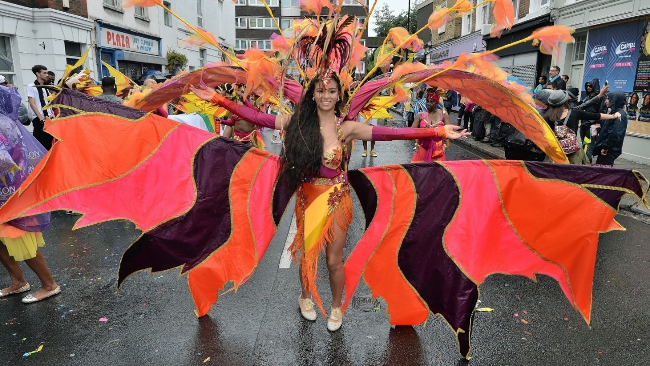 Participants take part in a rainswept Notting Hill Carnival in west London