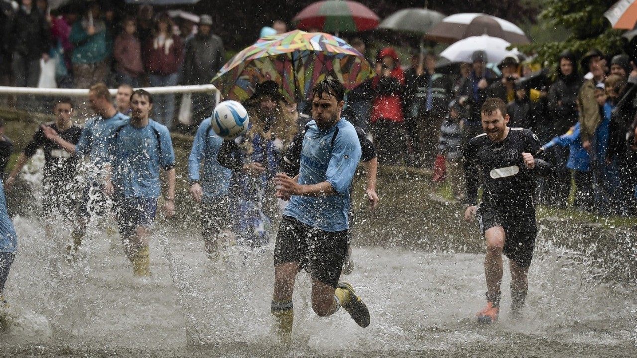 The annual Football In The River match at Bourton-in-the-Water, Gloucestershire, where a game of two 15 minute halves of football are played in the River Windrush on the high street in the village
