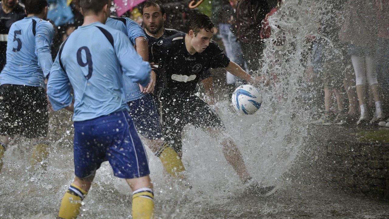 The annual Football In The River match at Bourton-in-the-Water, Gloucestershire, where a game of two 15 minute halves of football are played in the River Windrush on the high street in the village