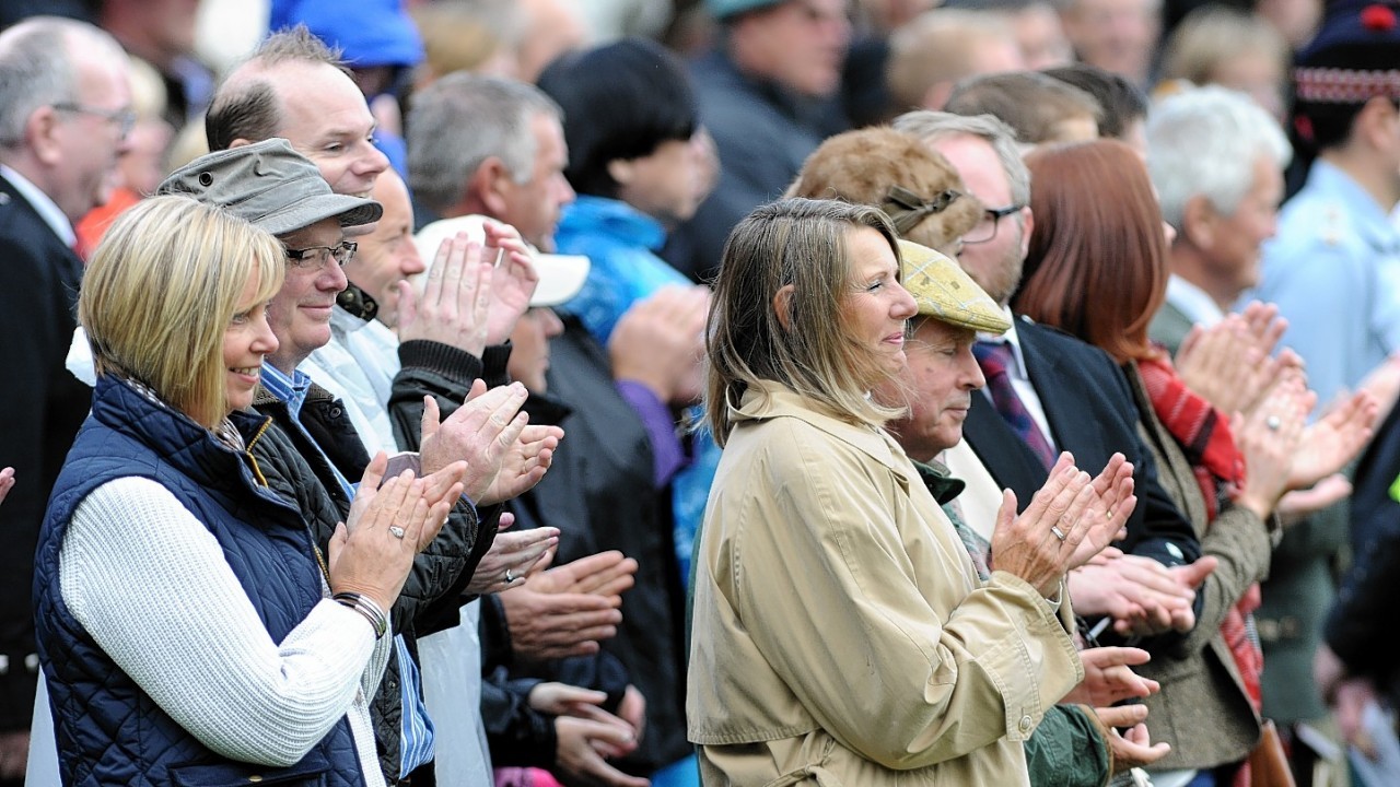 The crowd applauds the Queen's arrival. Credit:  Kami Thomson.