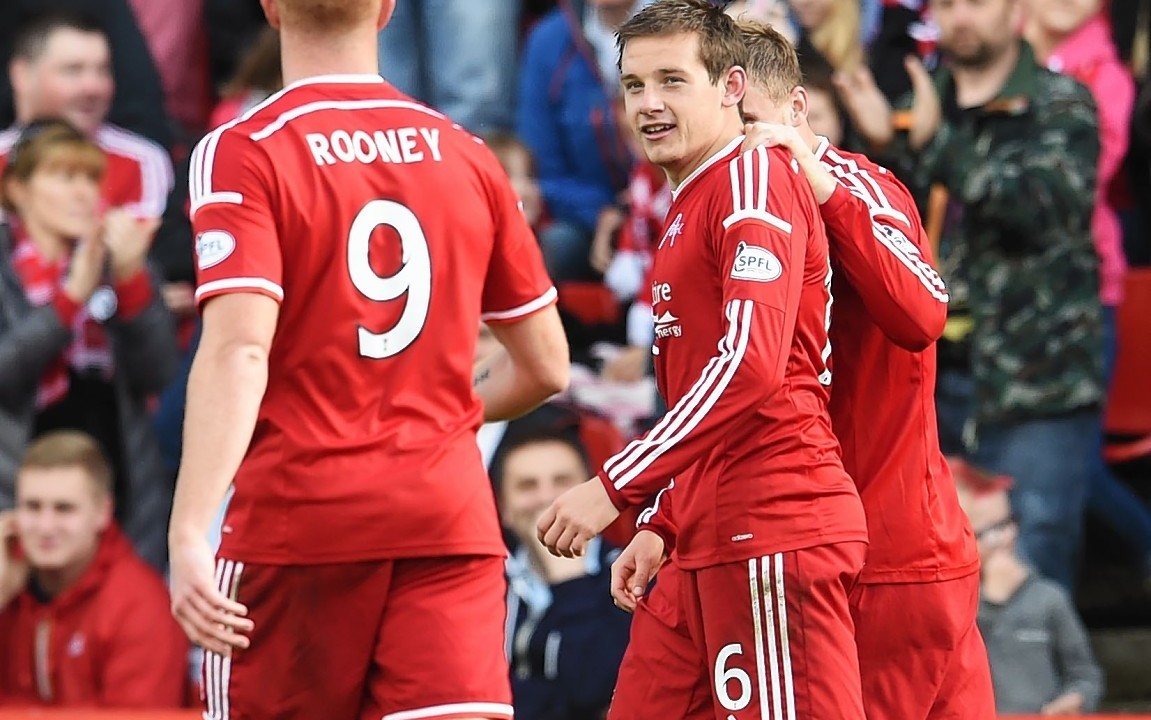 Peter Pawlett is congratulated by his team mates after netting the Dons' third goal
