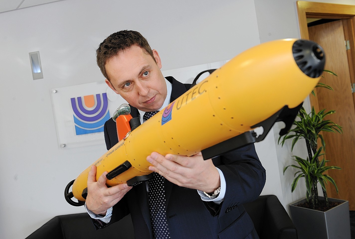 Utec's Kevin McBarron with a scale model of the company's autonomous underwater vehicle technology