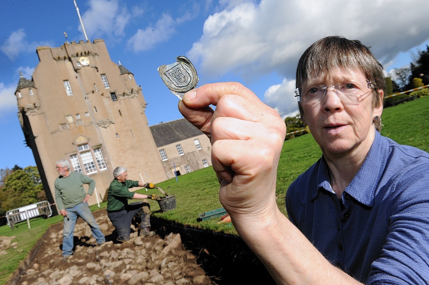 Volunteer Veronica Ross with a bottle seal showing the Burnett Coat Of Arms found at an archaeological dig at Crathes Castle.
