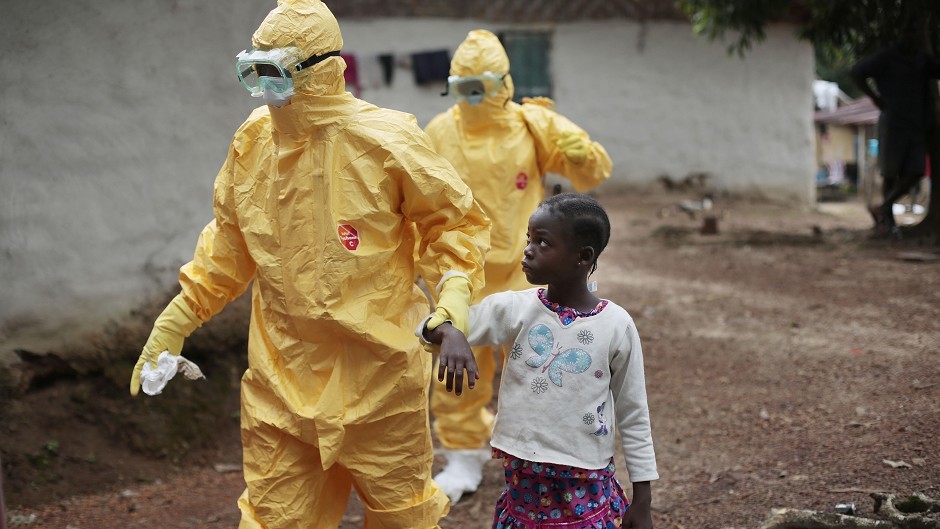 A nine-year-old girl is taken to an ambulance after showing signs of the Ebola infection in Liberia. (AP)