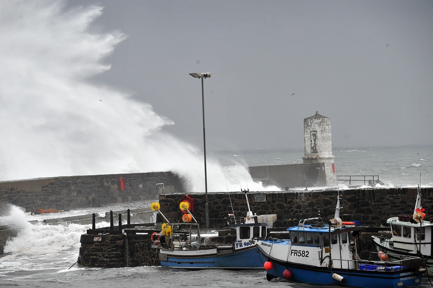 Waves from the Moray Firth batter Rosehearty Harbour yesterday