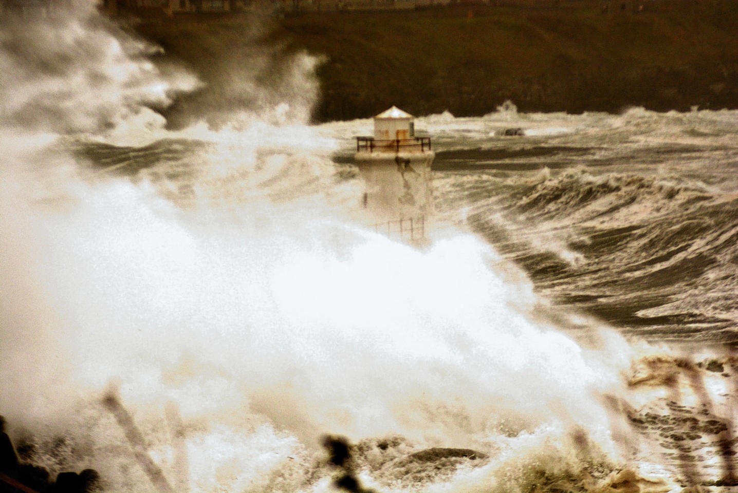 Waves engulf a lighthouse in Wick yesterday