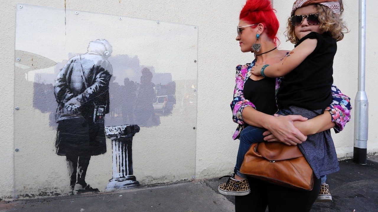 Local people view a mural called Art Buff created by street artist Banksy which appeared in Folkestone, Kent, during last weekend.