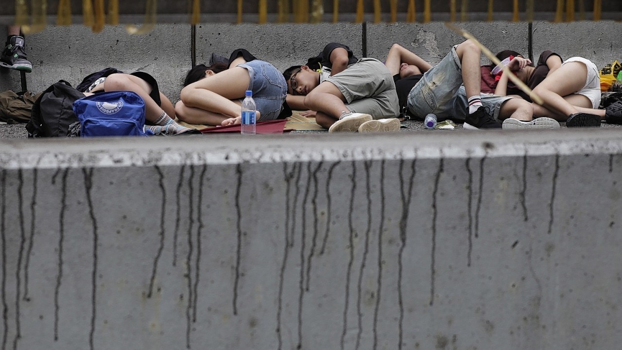 Pro-democracy student protesters sleep on an occupied main street outside of the government complex in Hong Kong