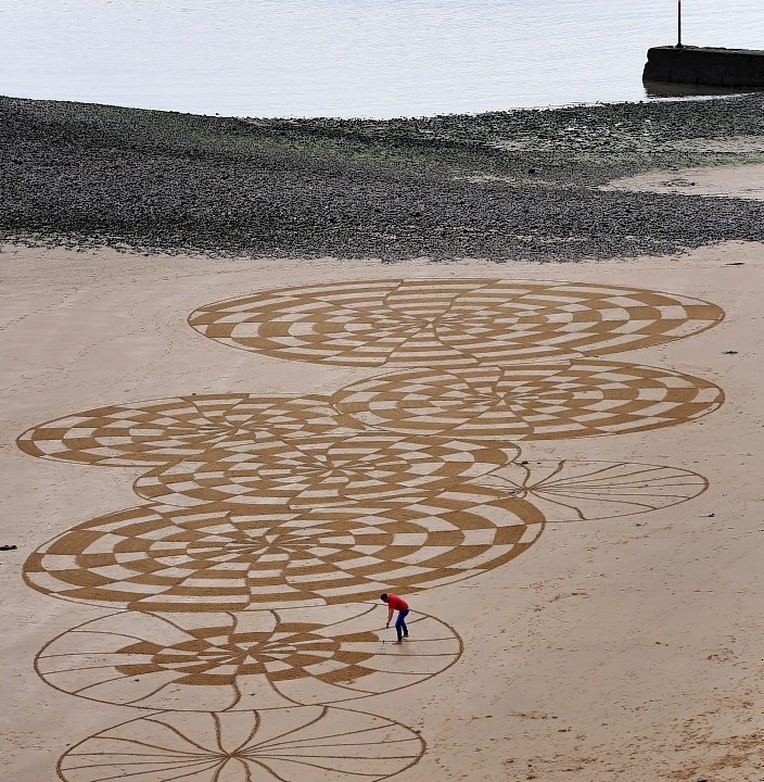 Sand artist Ross Andrews at work on a piece entitled 'Legacy No.II' on Ramsgate beach in Kent