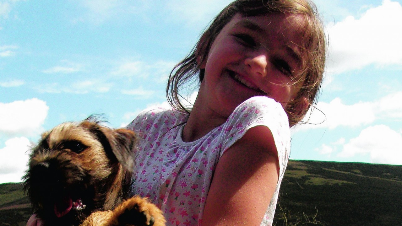 Border terrier Brodie who lives with Bob and Sheila Fraser in Letham, Angus, pictured  with their granddaughter Grace while visiting the Backwater Reservoir, Lintrathen.