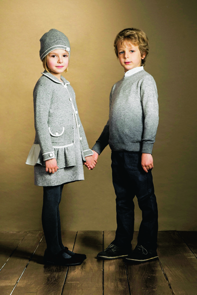 Girl wearing grey coat with front pockets, diagonal knot stitch set and hat. Boy wearing Corean shirt with contrast boarders and jumper, all from Cashmirino