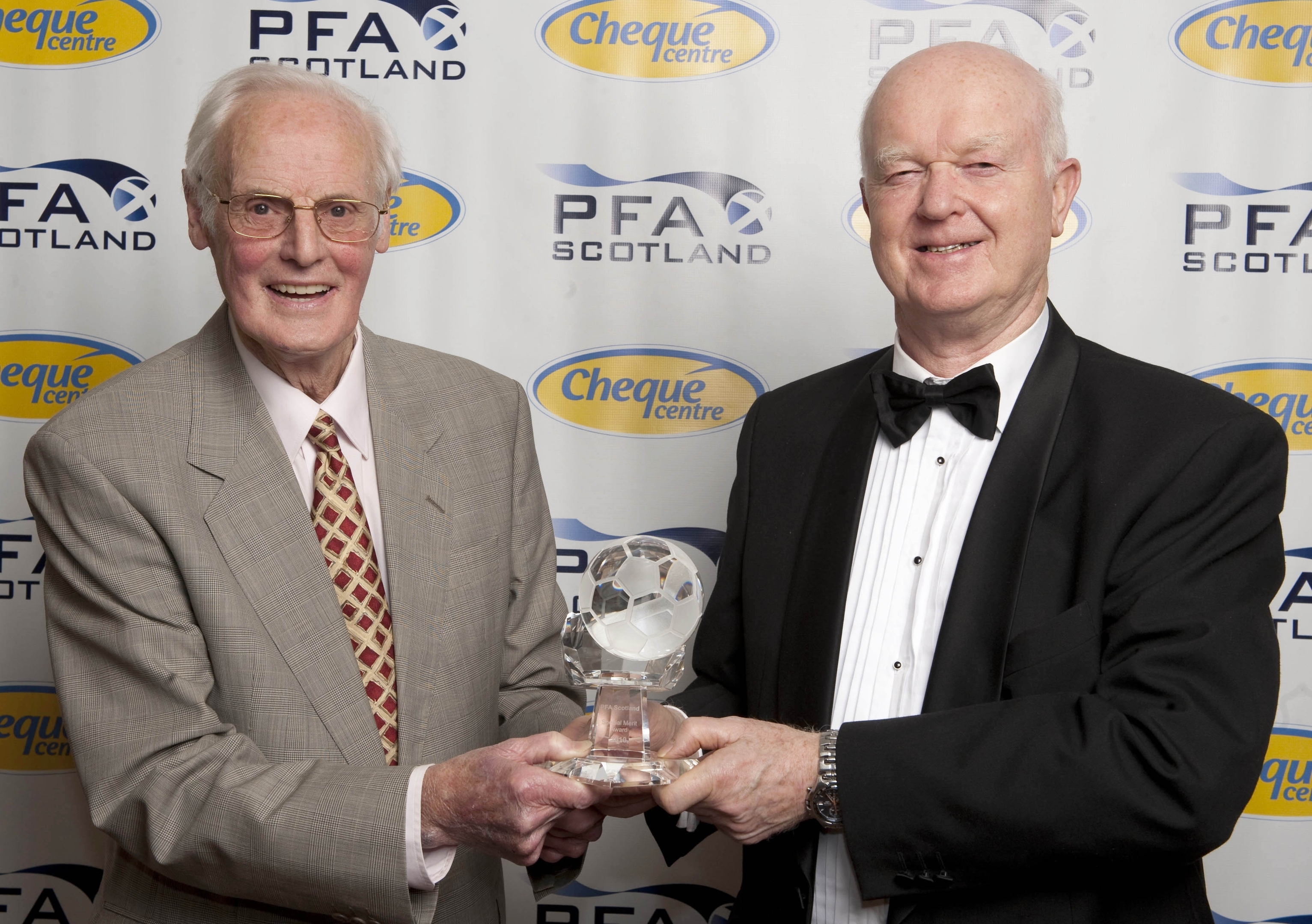Arthur Montford (left) receives a Special Merit Award from Archie MacPherson.