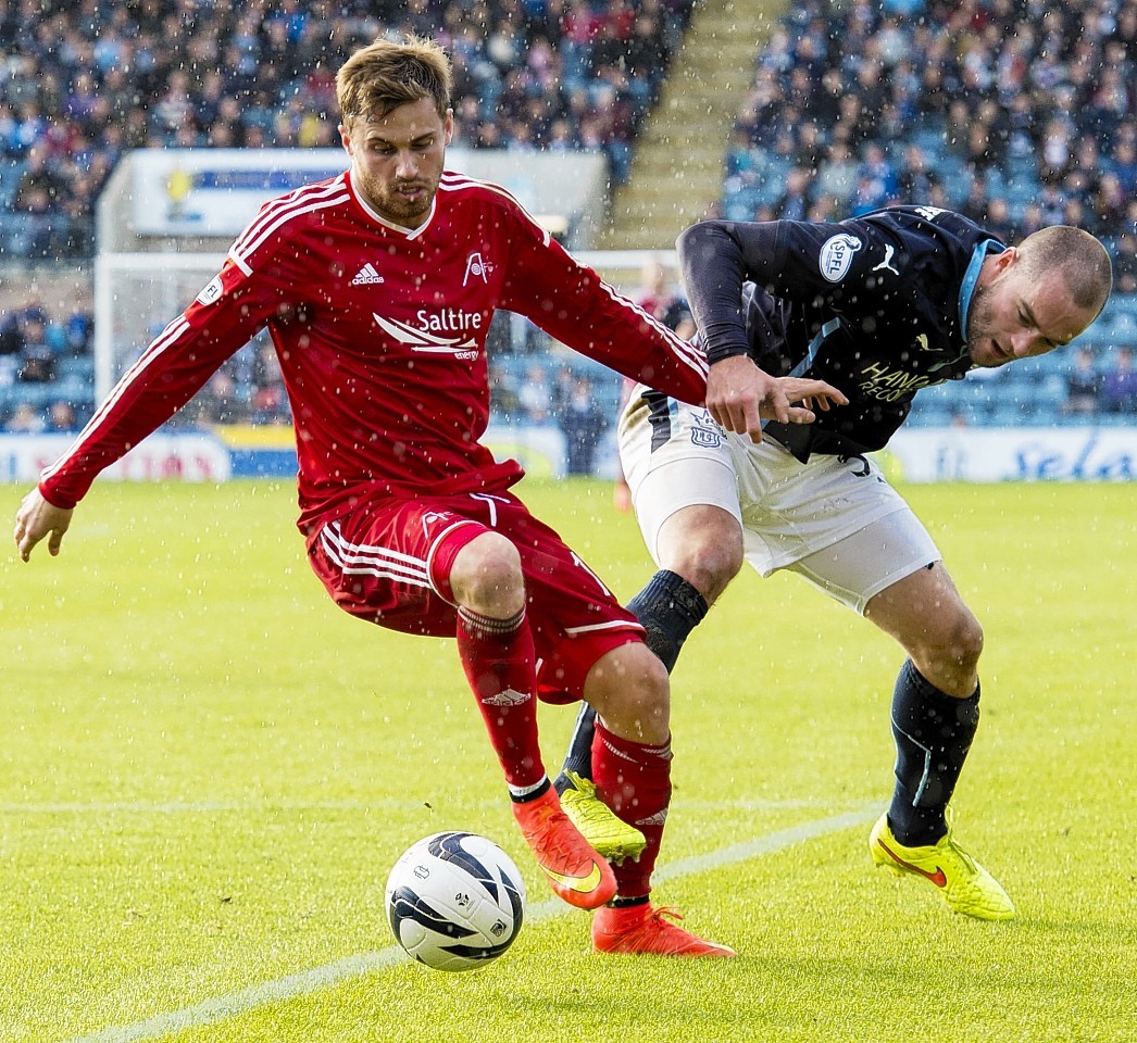 Dundee defender James McPake challenges Dons striker David Goodwillie.