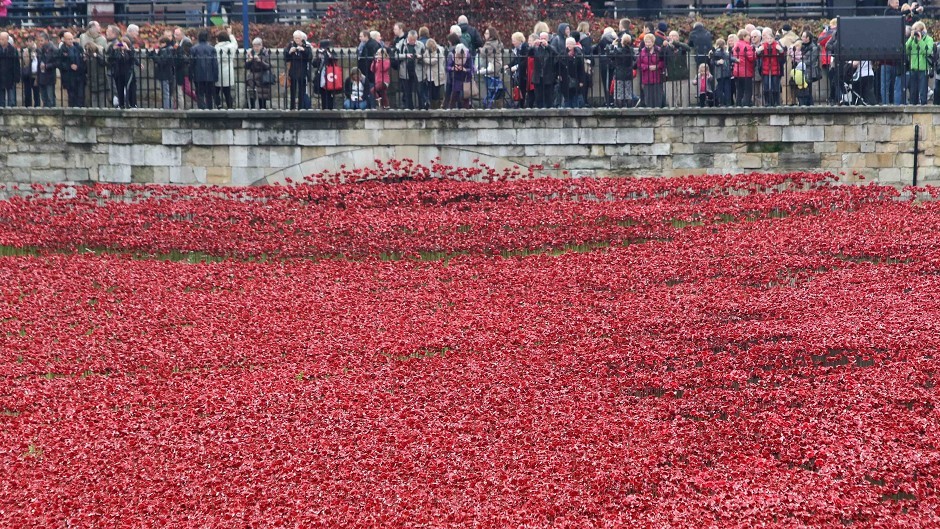 Visitors on Remembrance Sunday look the art installation 'Blood Swept Lands and Seas of Red' by artist Paul Cummins at the Tower of London