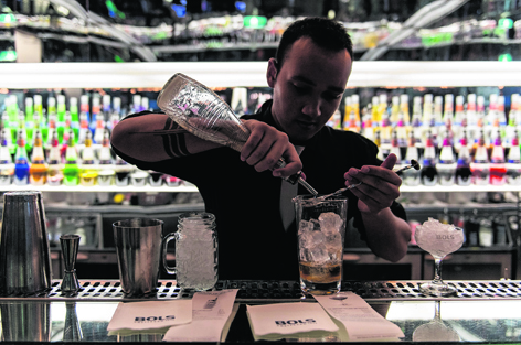 A bartender prepares a cocktail using Bols Genever at The House of Bols