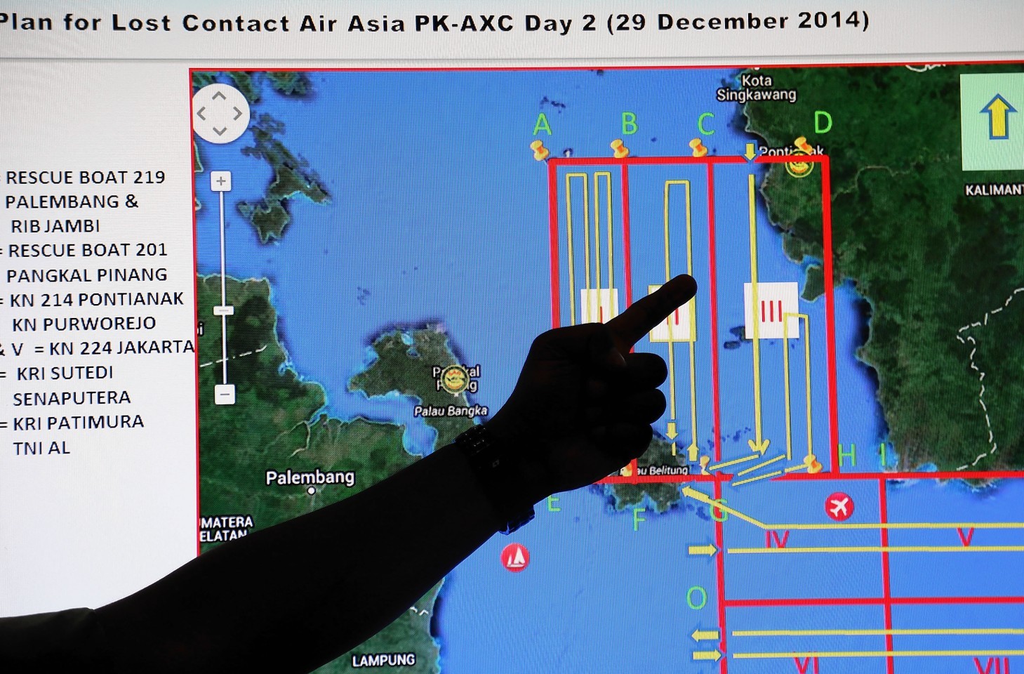  A member of the Indonesian National Search and Rescue Agency (BASARNAS) points to a map of a search area during a briefing prior to a search and rescue operation of the missing AirAsia flight QZ8501