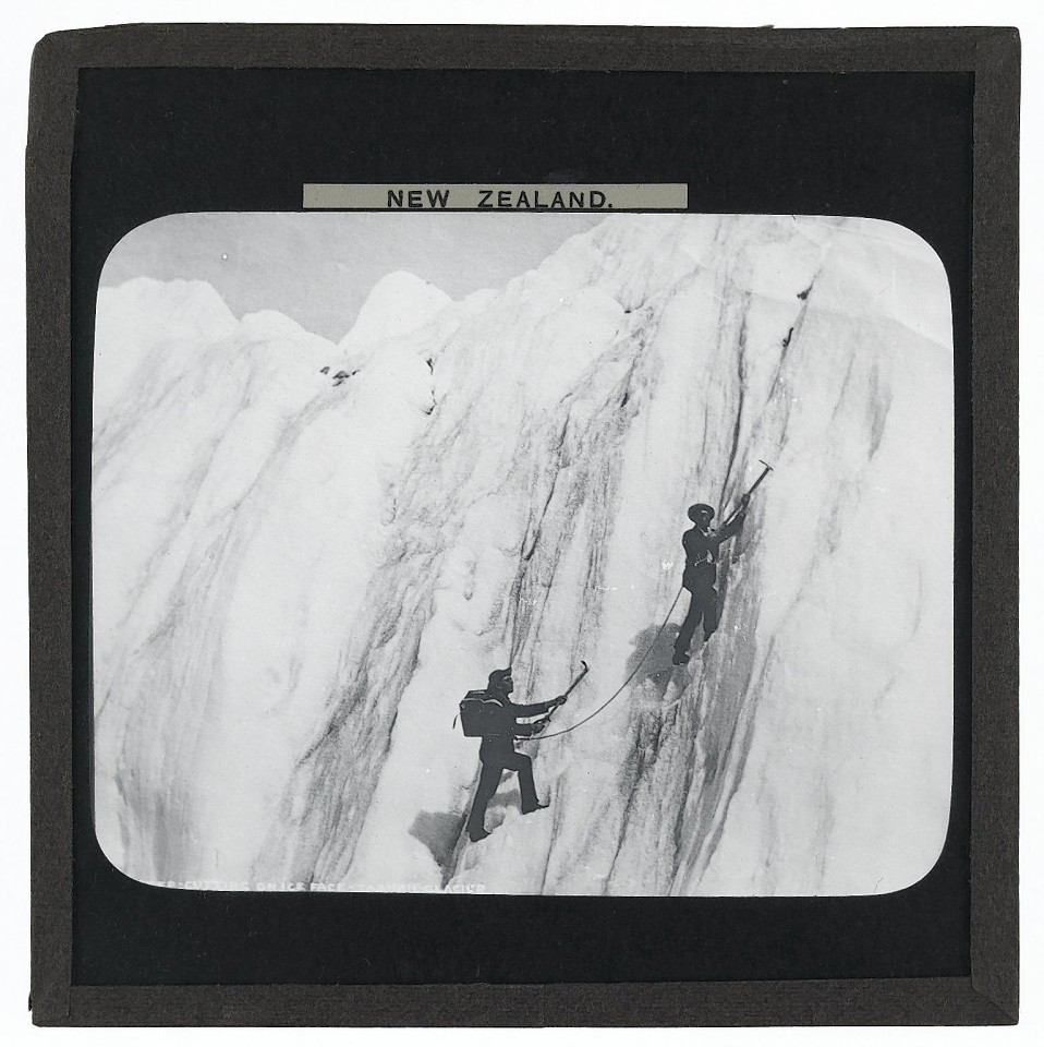 Step Cutting on Ice Face, Tasman Glacier, New Zealand. Photograph of two men step cutting on the ice face of the Tasman Glacier, New Zealand in the late 19th or early 20th century