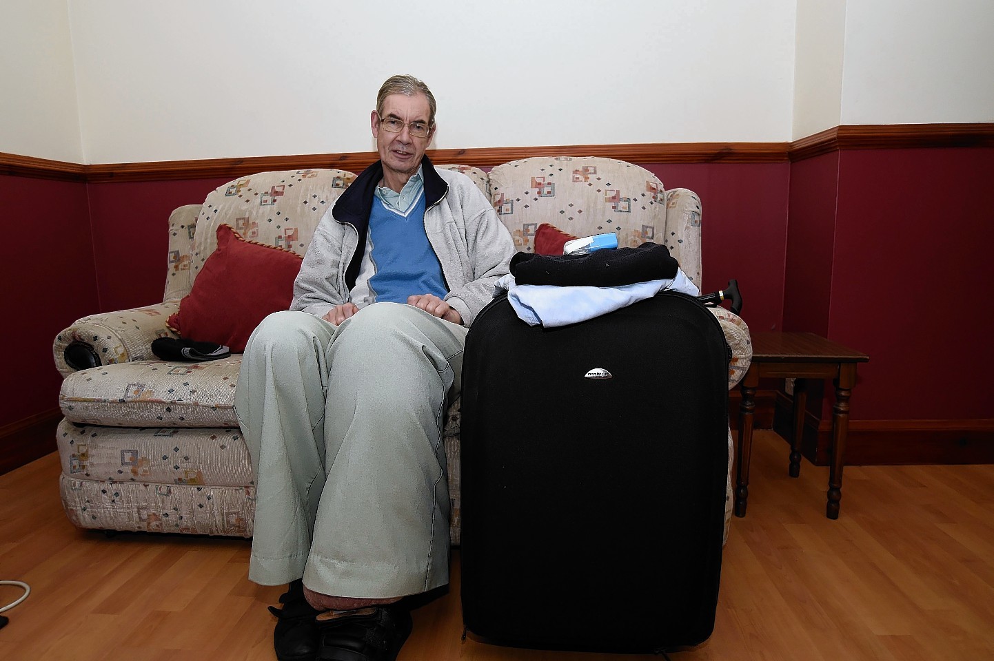 Michael Cull sits by a suitcase he had packed ready for surgery