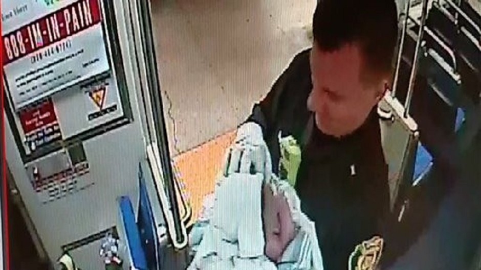 Philadelphia transit police Sergeant Daniel Caban holds a baby boy he helped deliver aboard a subway train in Philadelphia (AP/SEPTA)