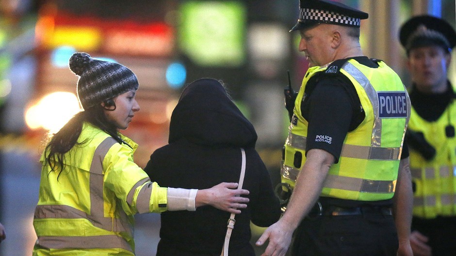 A member of the public is comforted by members of the emergency services close to the scene in Glasgow's George Square
