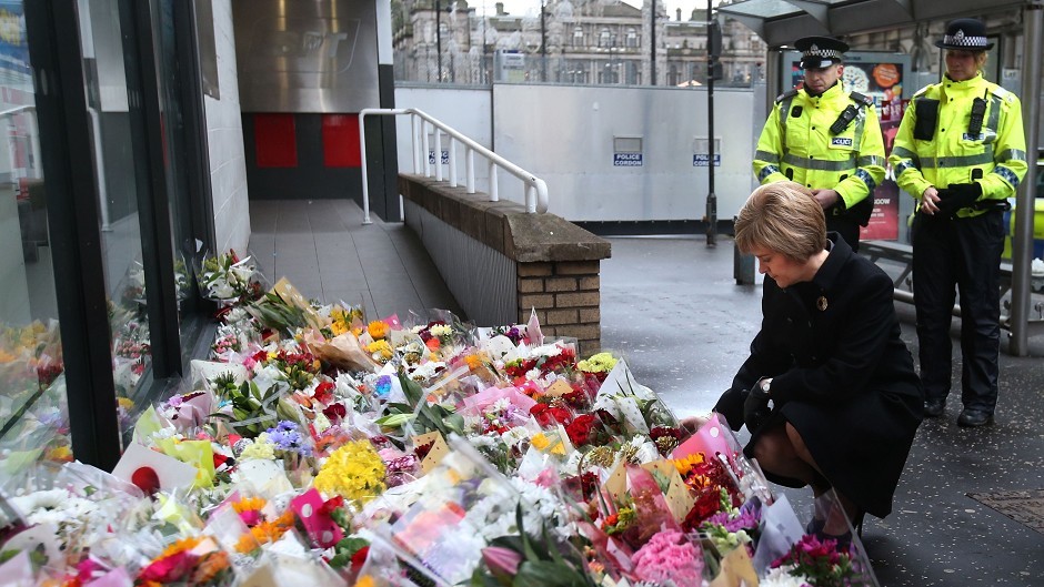 First Minister Nicola Sturgeon views flowers left near to the scene of yesterday's bin lorry crash in Glasgow