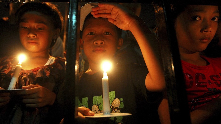 Indonesian children hold candles to pray for the victims of AirAsia Flight 8501 in Surabaya (AP)