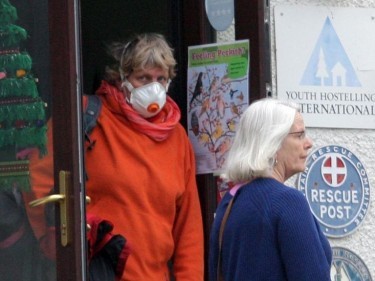 Woman leaves youth hostel with mask over her face