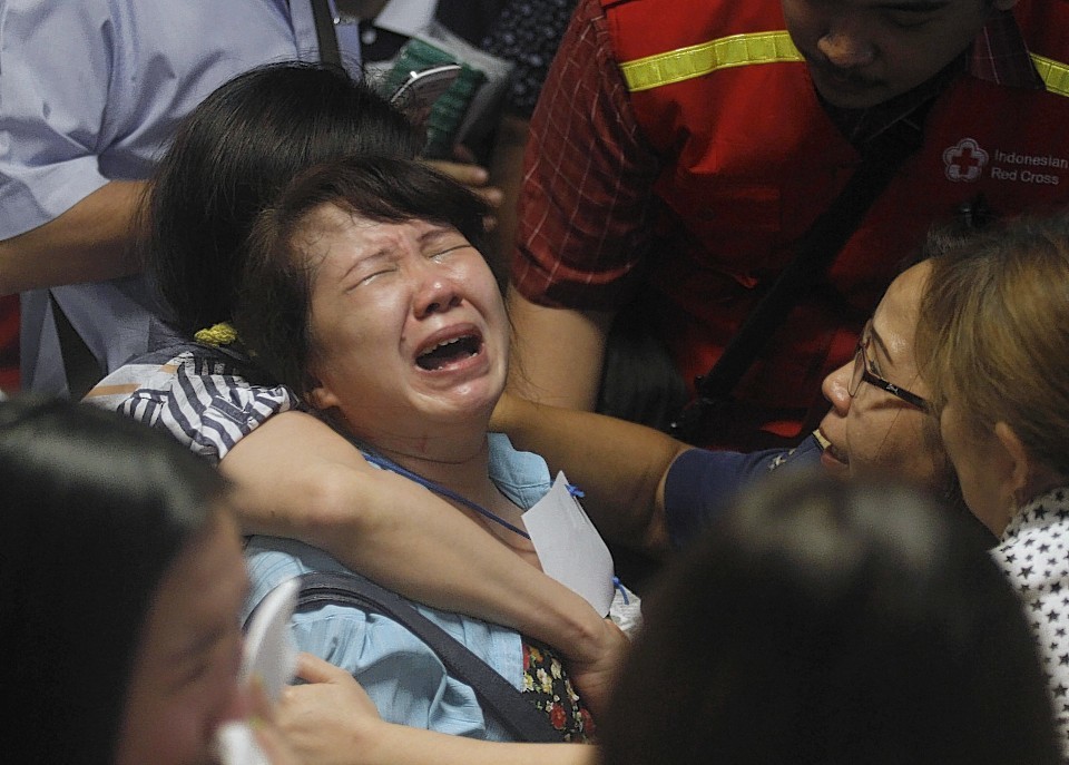 Relatives of passengers of the missing AirAsia flight QZ 8501 react to the news