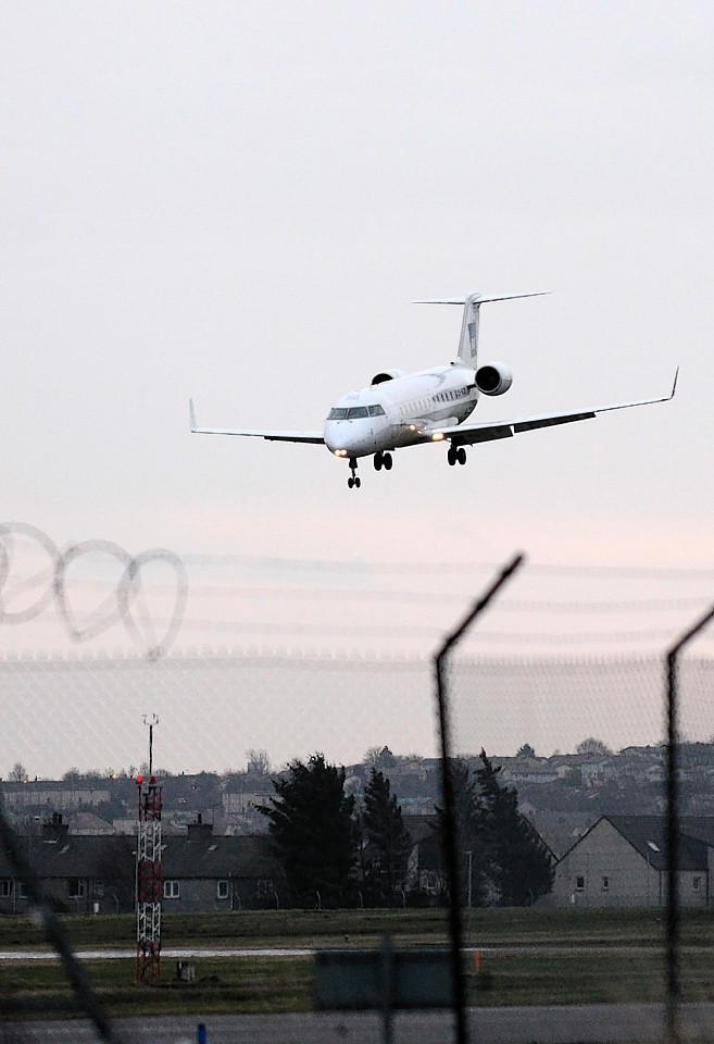 A plane approaches Aberdeen Airport runway in difficult weather