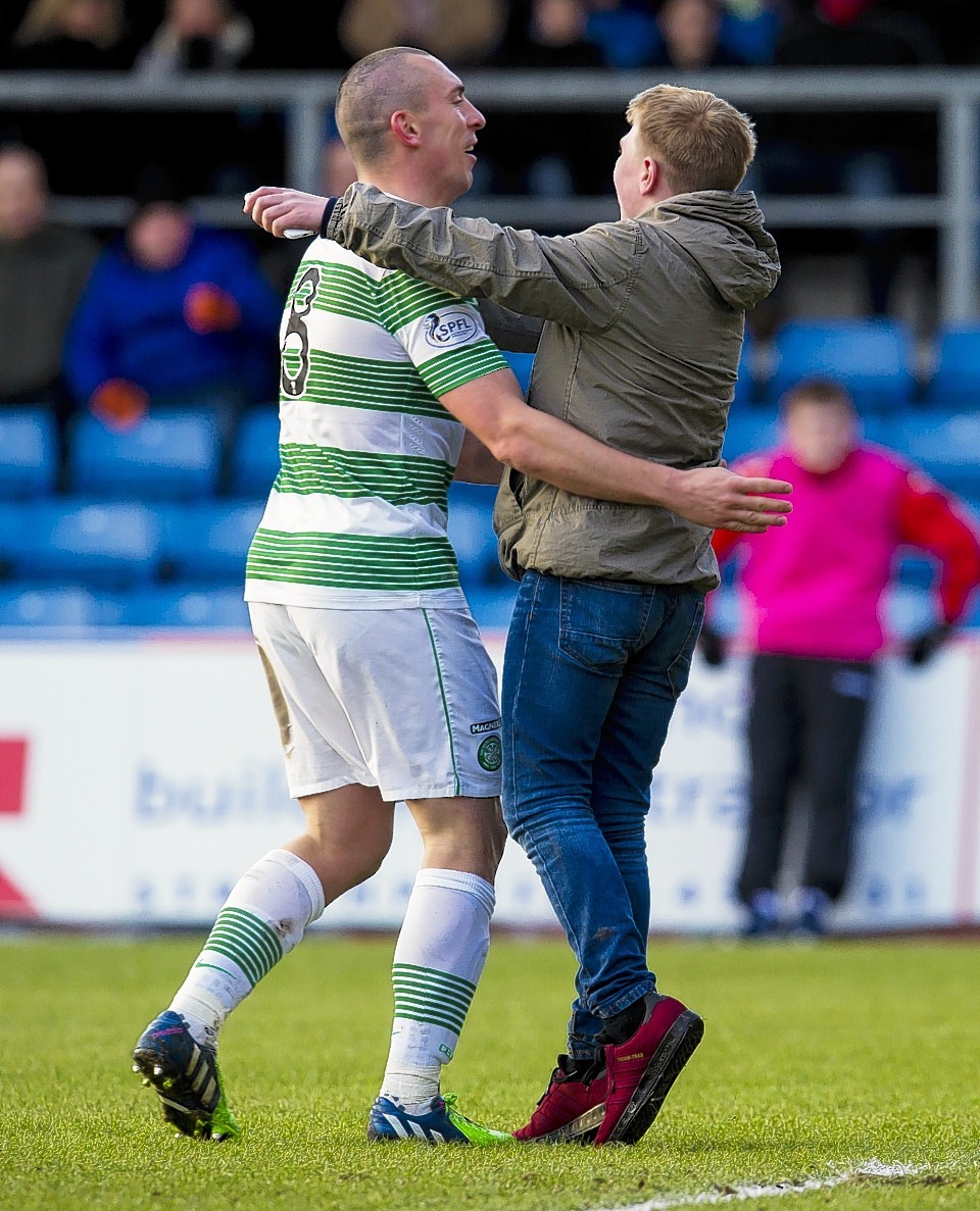 Scott Brown is greeted by a Celtic fans on the pitch