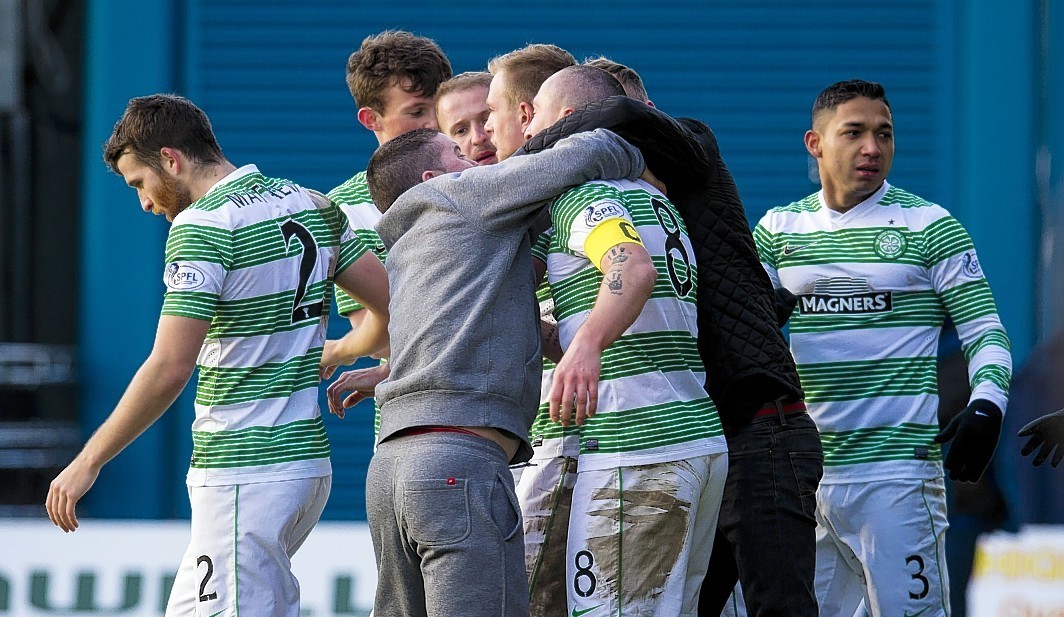 Celtic players and fans and players celebrate the winning goal from  Kris Commons