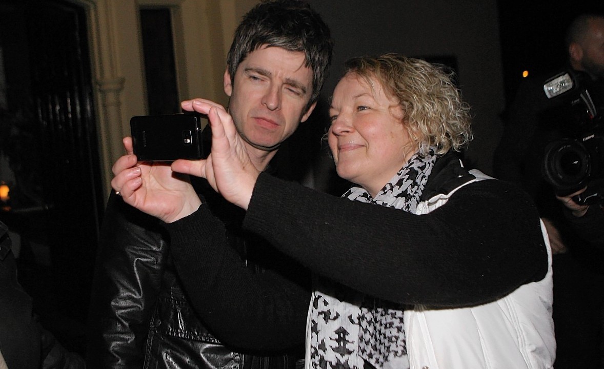 Noel Gallagher poses for a picture outside the hotel