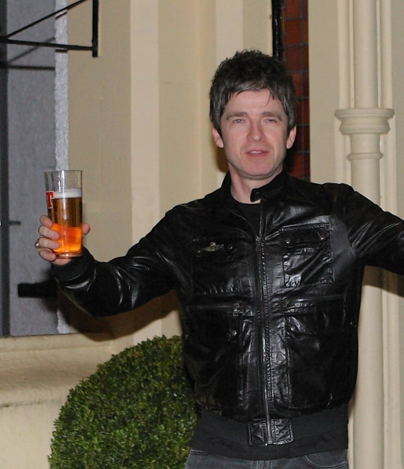 Noel Gallagher arrives to sign autographs outside the hotel, pint in hand