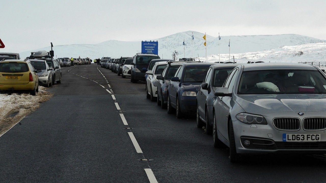 Cars line the busy A82 at Glencoe Mountain Resort .