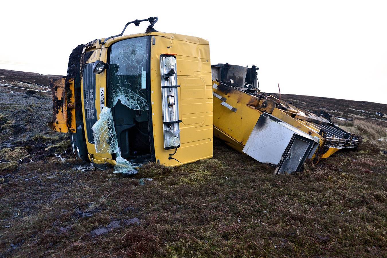 The overturned gritter lying beside the road