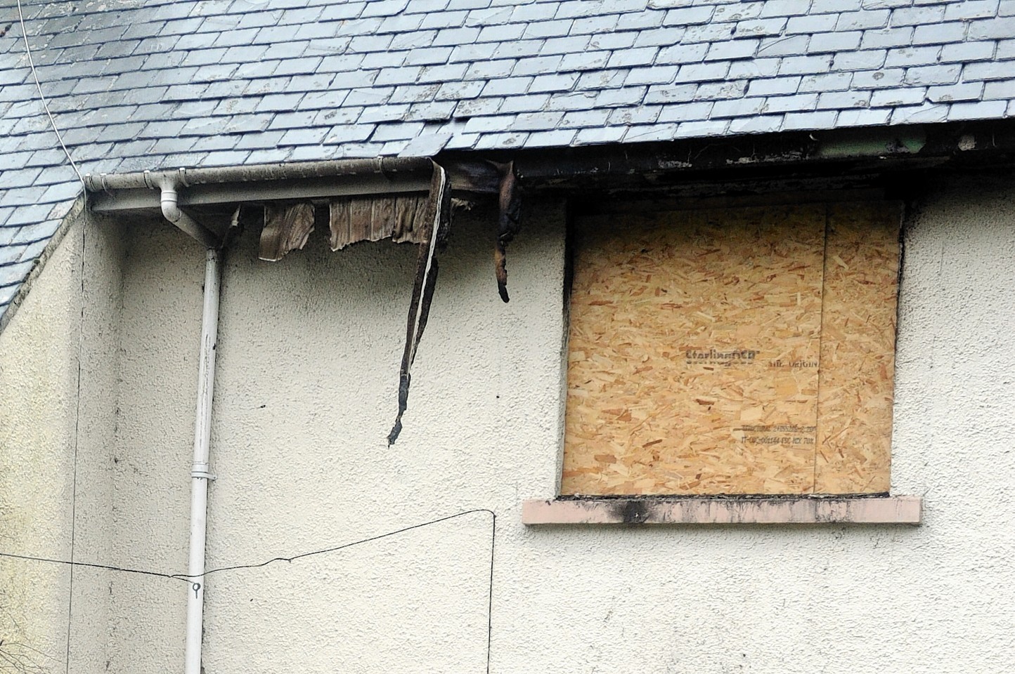 The boarded up exterior of the house in Lochend