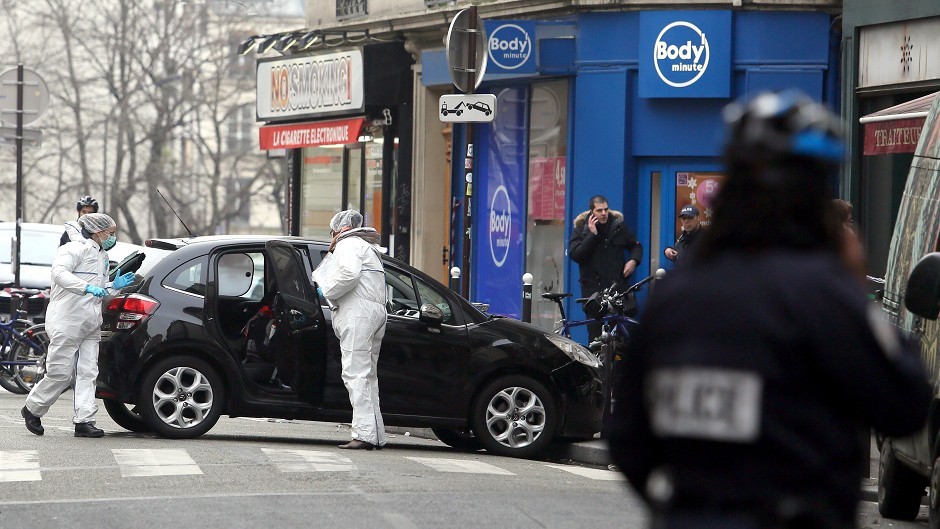 Forensic experts examine the car believed to have been used as the escape vehicle by gunmen who attacked the French satirical newspaper Charlie Hebdo's office, in Paris (AP)