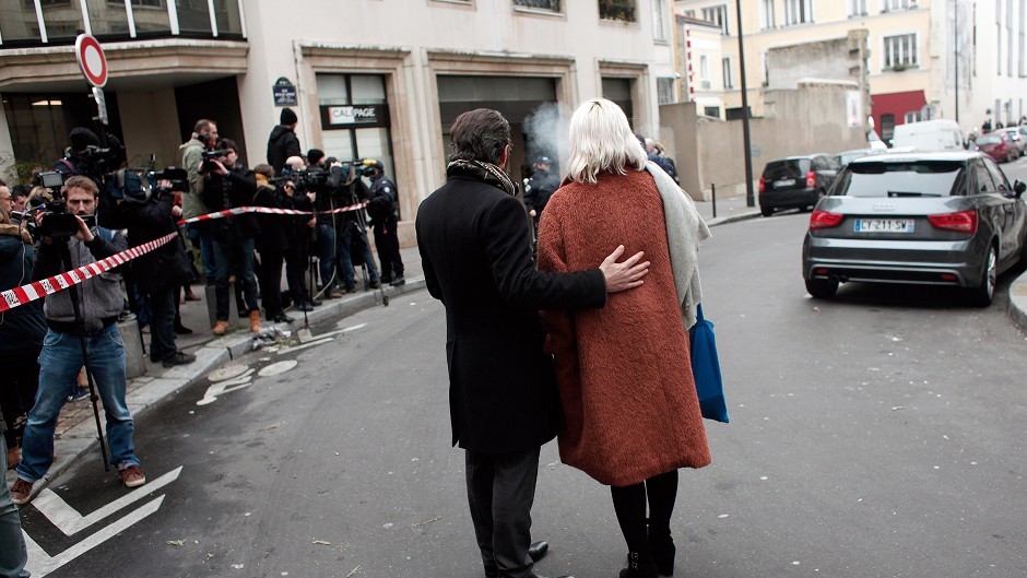 People stand outside the French satirical newspaper Charlie Hebdo's office after a shooting in Paris. (AP)