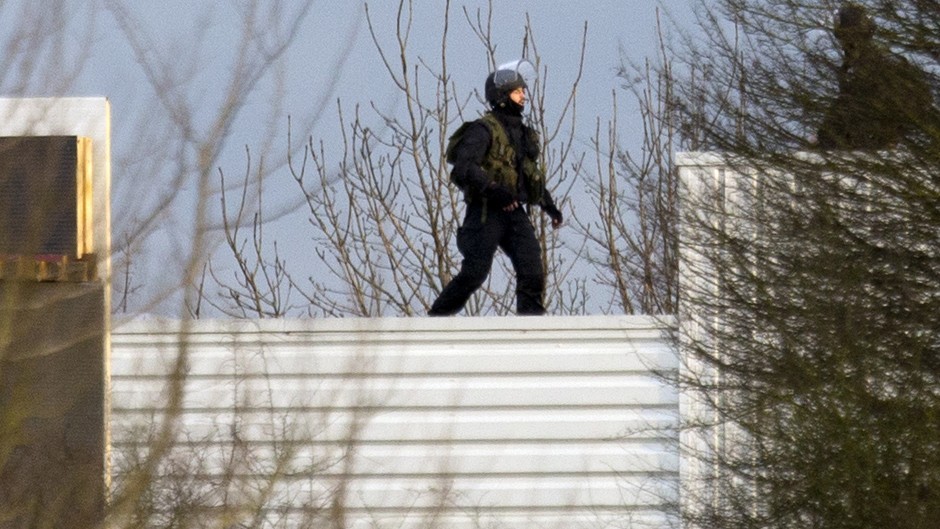 An armed police officer stands on the roof of a building in Dammartin-en-Goele, north-east of Paris, where the two brothers suspected in a deadly terror attack were cornered (AP)