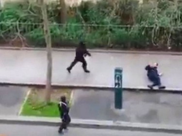 Masked gunman run towards a victim of their gun fire  outside the  French satirical newspaper Charlie Hebdo's office