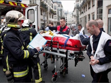 An injured person is carried into an ambulance after a shooting, at the French satirical newspaper Charlie Hebdo's office