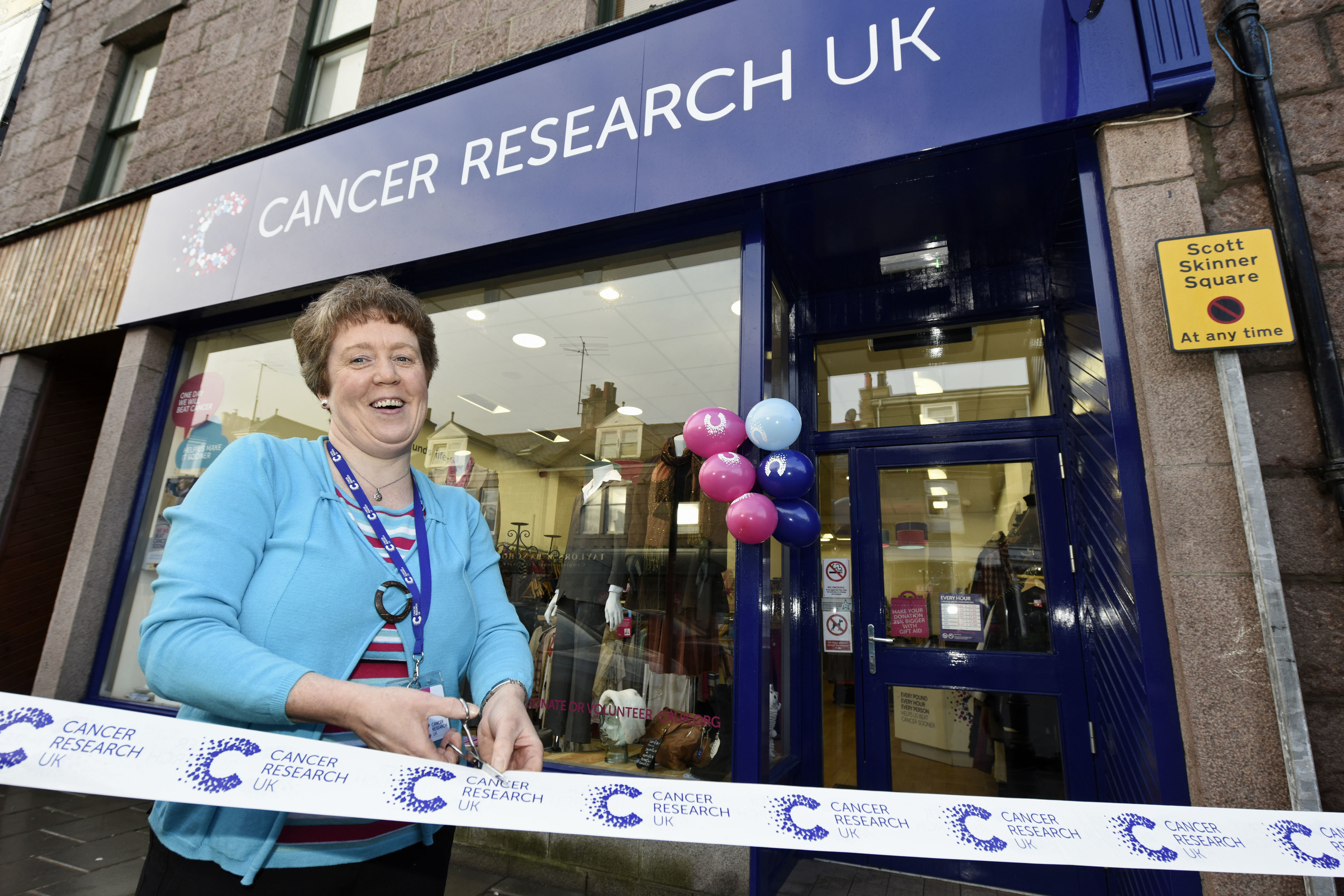 Yvonne Thomson, new manager of Cancer Research UK shop in Banchory cuts the ribbon