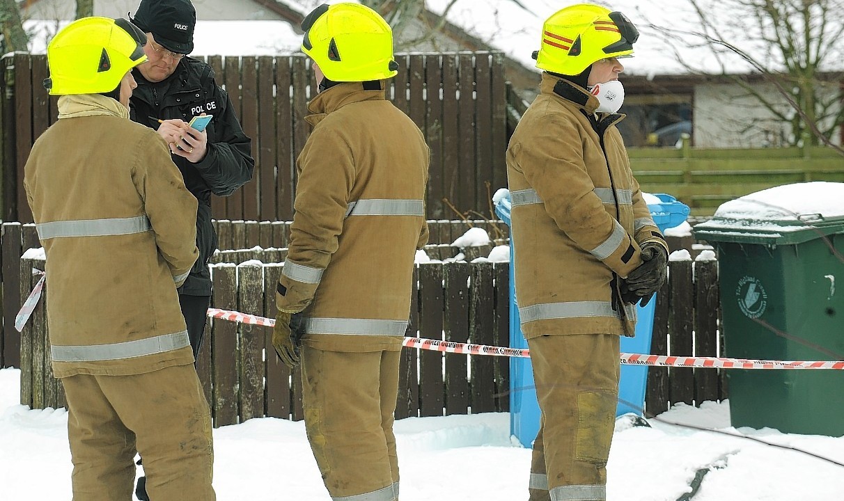 Police and fire services at the burnt out house in Aviemore where a man has been found dead