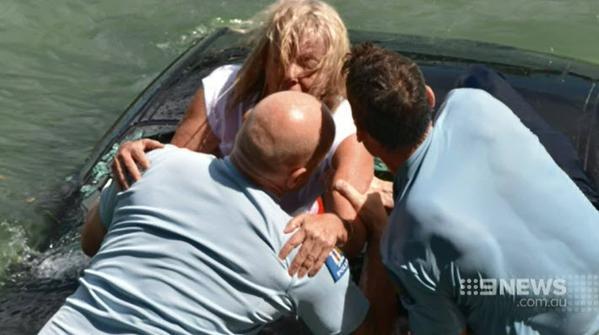 Police officers pull the woman from the back of the car in Waitemata Harbour, Auckland, New Zealand